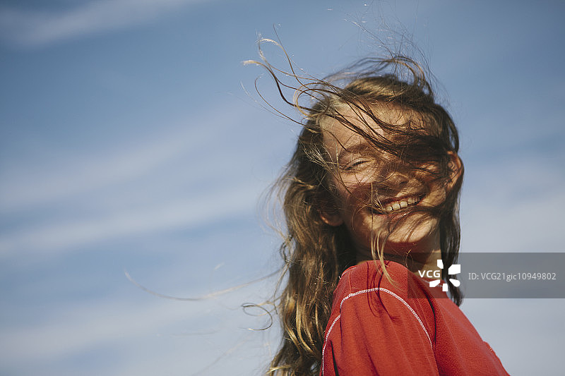 面带微笑的九岁女孩，微风吹拂着她的头发图片素材