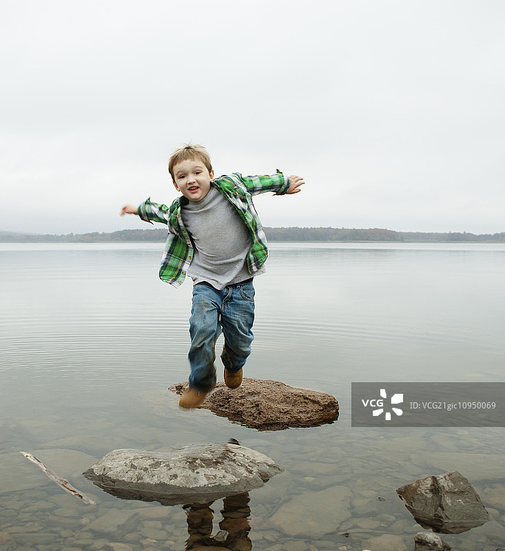 男孩在阿索坎湖跳过垫脚石图片素材
