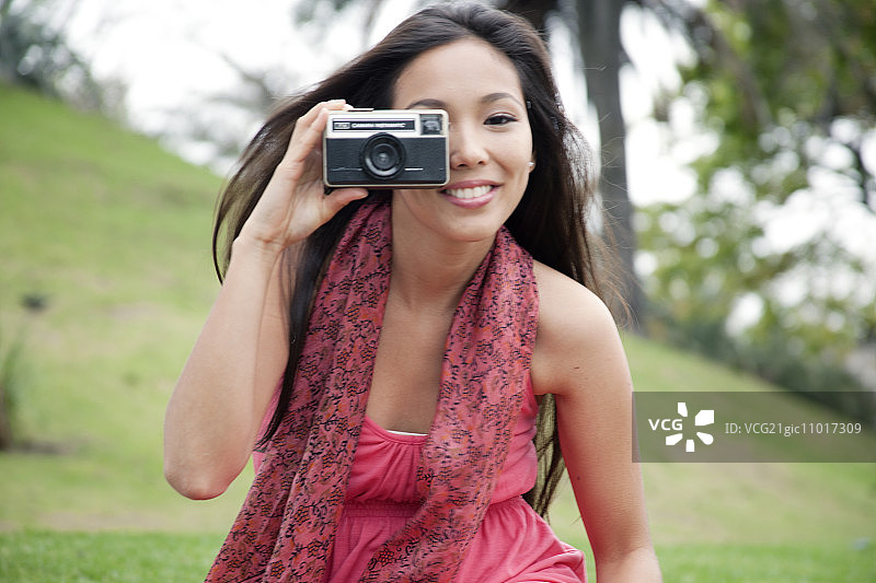 年轻女子用相机拍照图片素材