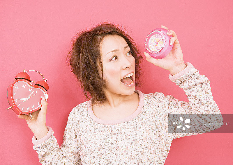 一名女子拿着闹钟图片素材