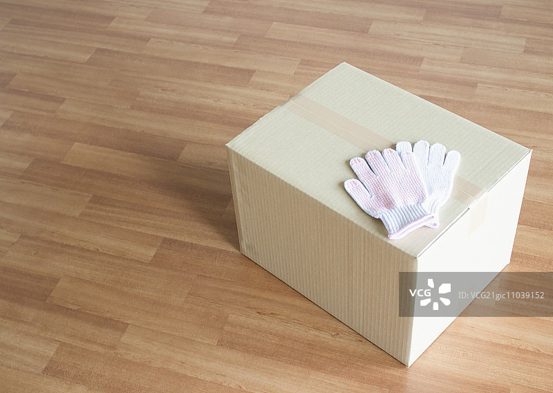 木地板上的纸板箱和工作手套图片素材