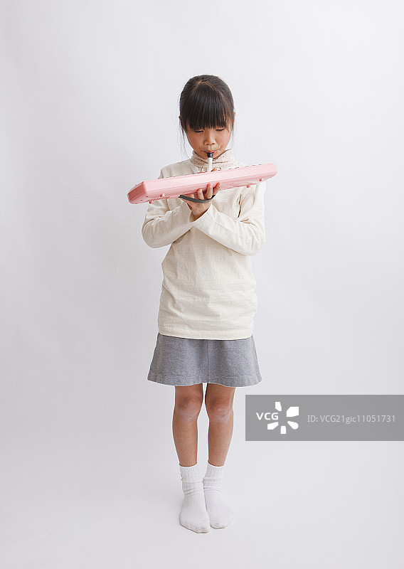 女孩演奏美乐迪卡琴图片素材