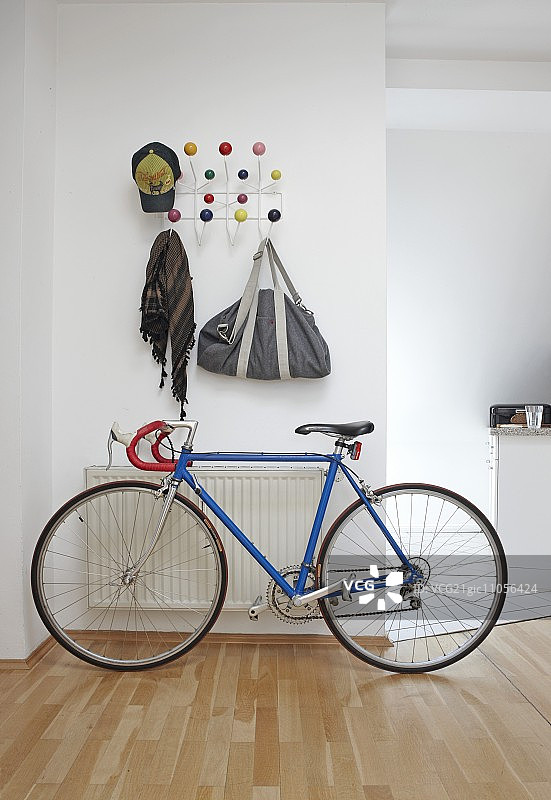 开放式现代走廊赛车自行车上方的白色金属丝彩色球形挂钩衣架图片素材