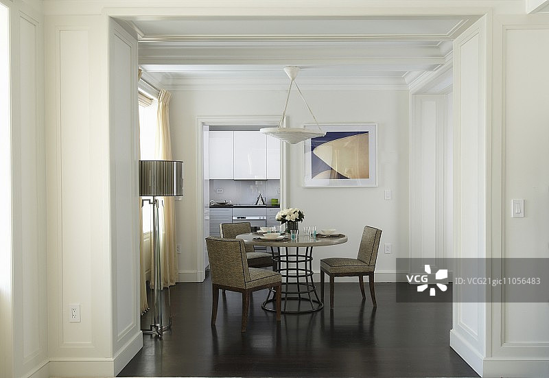 透过宽阔的门口看到的带有圆桌和软垫椅的餐厅图片素材