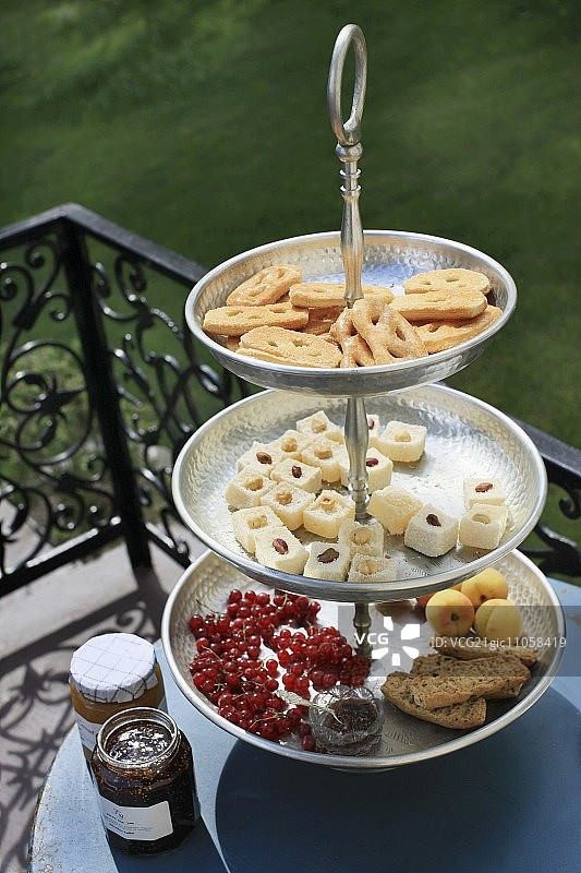 阳台桌上的多层蛋糕架和精致小点心图片素材