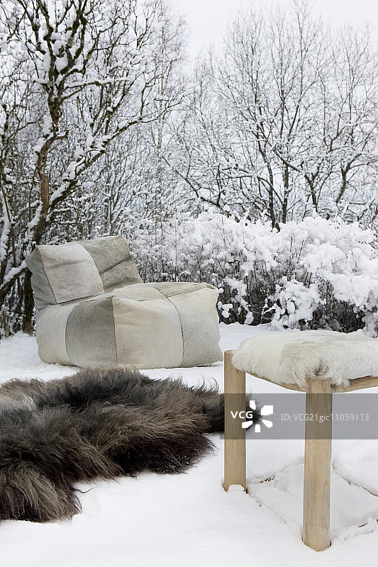 雪地里的豆袋、毛皮地毯和毛皮凳子图片素材