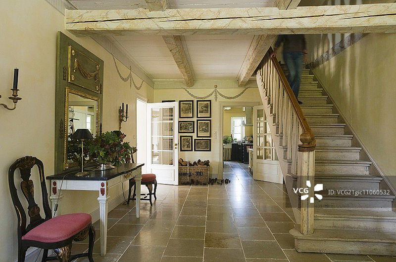 入口大厅，铺有天然石材地板，楼梯上方是质朴的木梁天花板图片素材