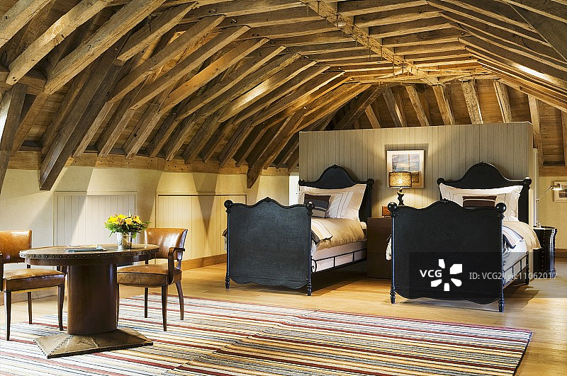 开放式阁楼房间内的黑色木制框架双人雪橇床图片素材
