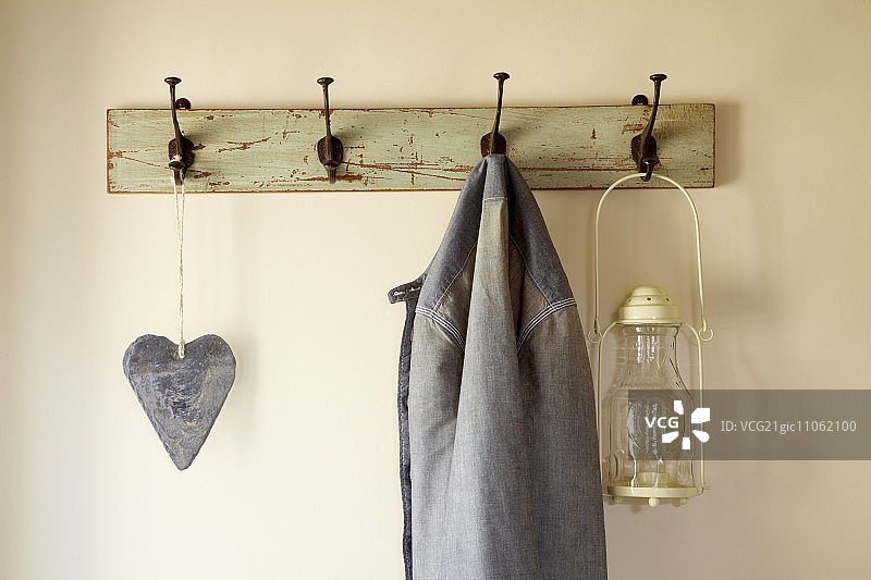 挂在旧衣帽架上的心形装饰品、外套和灯笼图片素材