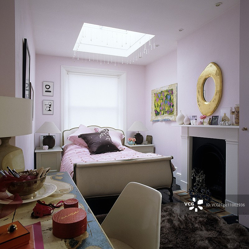 淡紫色传统卧室中的梳妆台雪橇床和壁炉图片素材