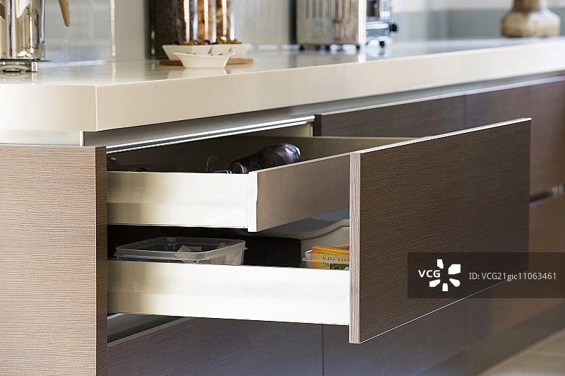 集成到厨房岛台中的棕色前板打开的抽屉图片素材