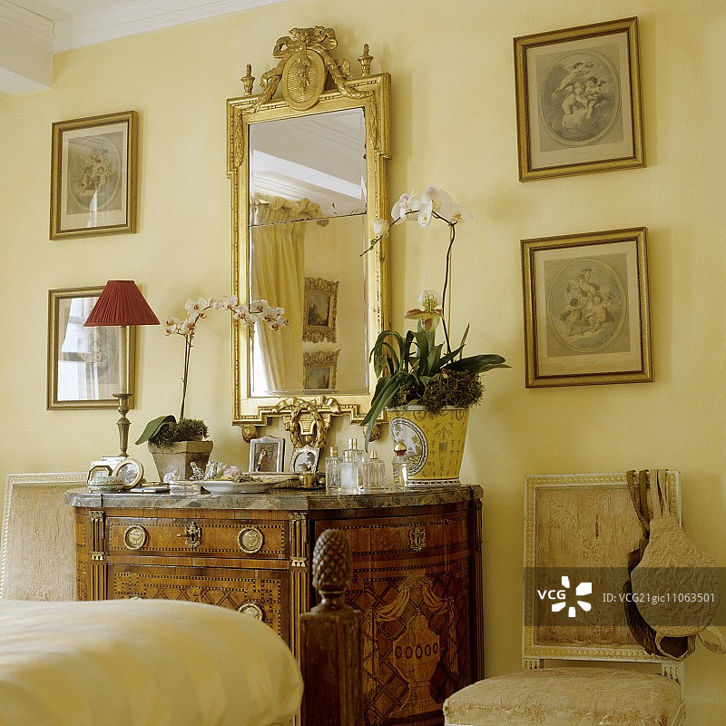 卧室里的古董木制抽屉柜和金色镜子图片素材