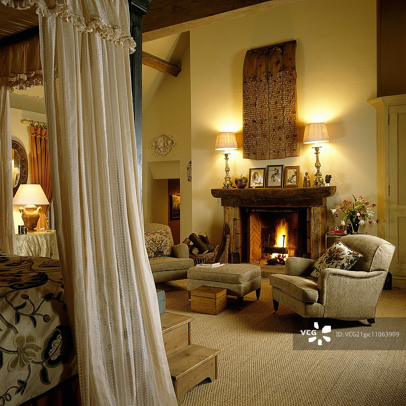 壁炉前舒适的扶手椅和凳子图片素材