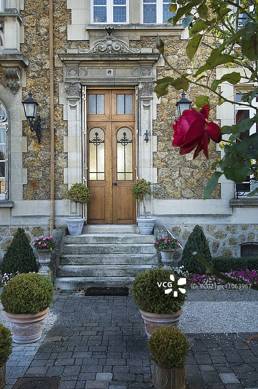 正式入口：前景是铺砌的花园小路，两侧是赤陶盆中的箱形球图片素材