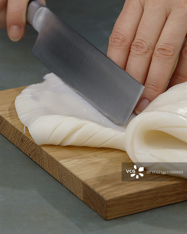 用锋利的刀将墨鱼切成菱形花纹图片素材