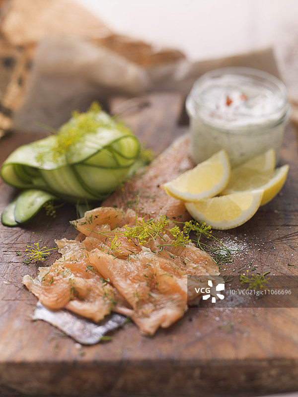 莳萝花腌制红点鲑鱼片配雷莫拉酱、黄瓜片和柠檬角图片素材