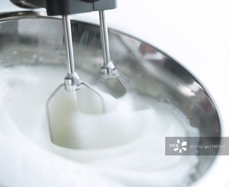 用电动手持搅拌器将蛋白打发图片素材