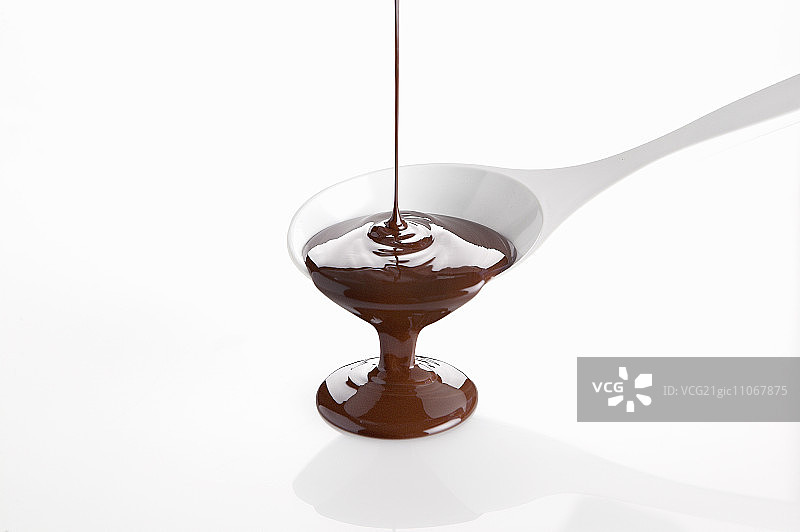 融化的巧克力从烹饪勺中倒出图片素材