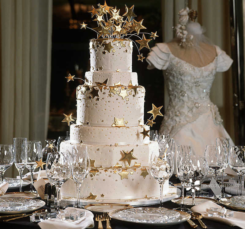 摆放在桌子上的金色星星多层结婚蛋糕图片素材