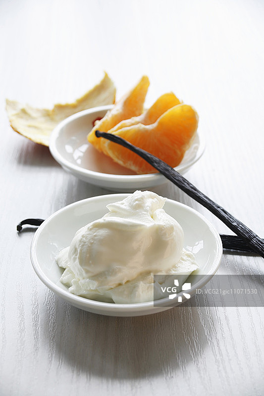 凝乳、橘子瓣和香草豆荚静物摄影图片素材
