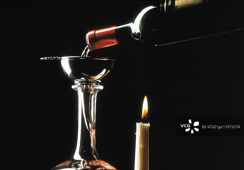 在蜡烛上倾倒红酒图片素材
