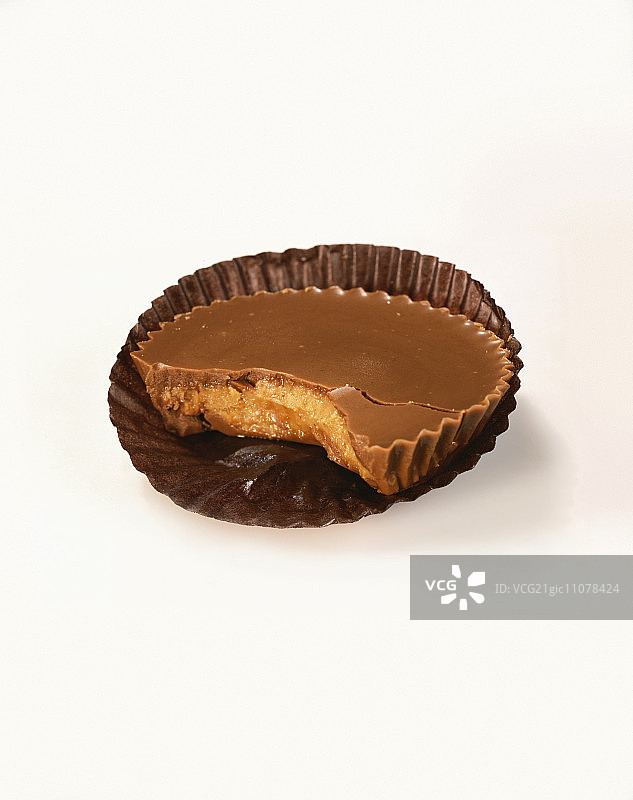 白色背景上的咬了一口的奶油花生酱杯图片素材