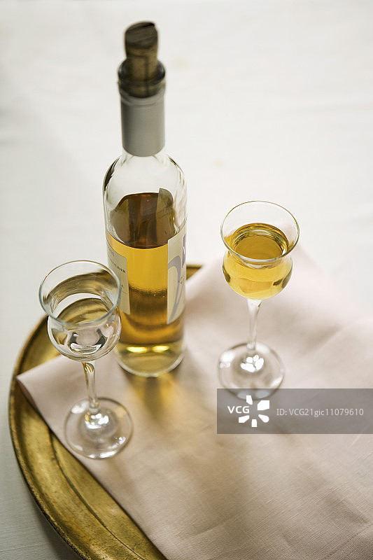 两杯苏玳葡萄酒，一杯满，一杯空图片素材