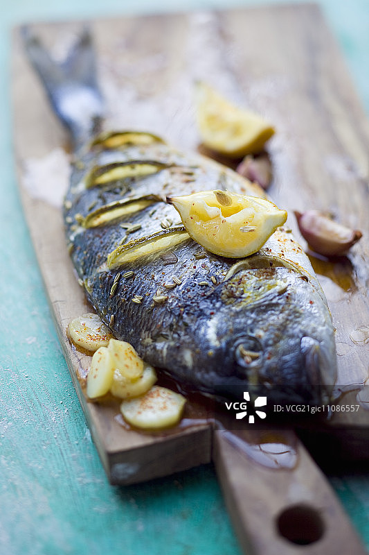 柠檬角和大蒜烤制的镀金头鲷图片素材