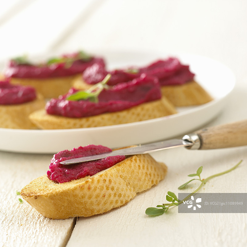 烤法棍片上的甜菜根酱图片素材