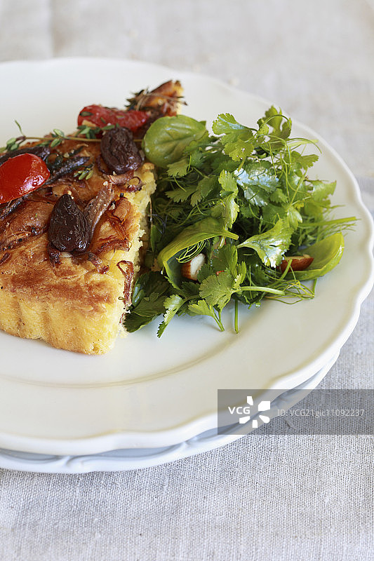 尼斯洋葱馅饼配橄榄、洋葱和番茄，配一份沙拉图片素材