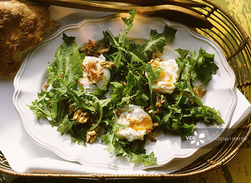 蒲公英沙拉配水波蛋、坚果和培根图片素材