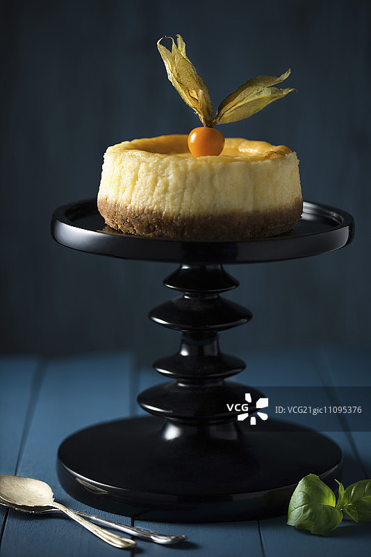 柠檬芝士蛋糕，蛋糕架上配有酸浆果图片素材
