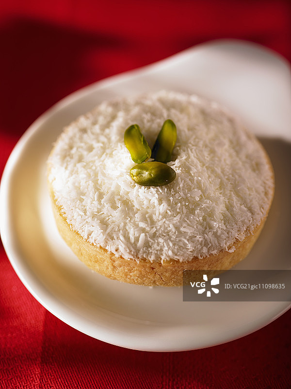 单份椰子蛋糕配羊奶酪和开心果图片素材