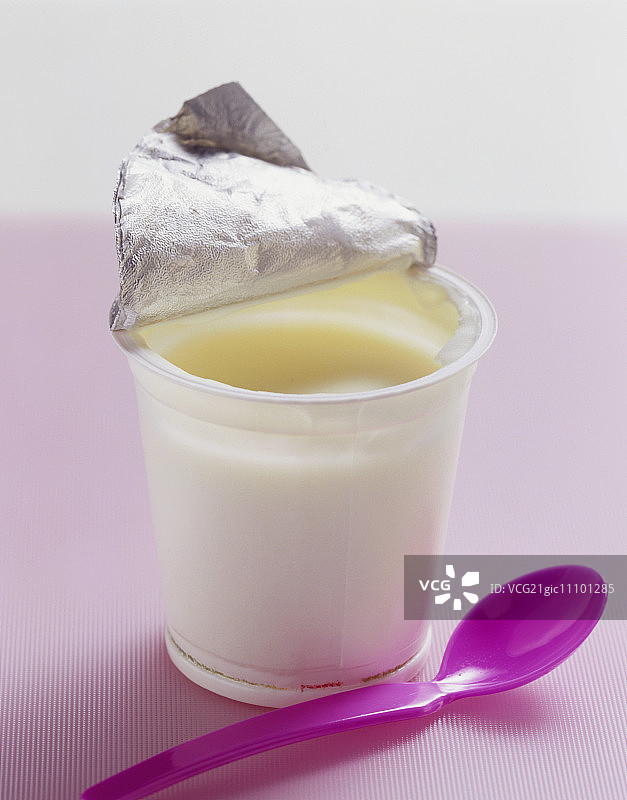 一罐配塑料勺的原味酸奶图片素材