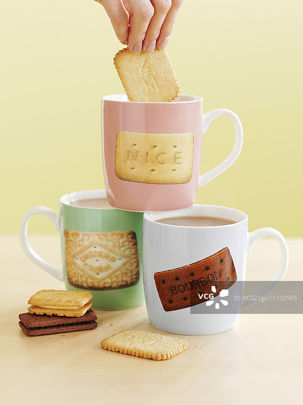 手将饼干浸入茶杯图片素材