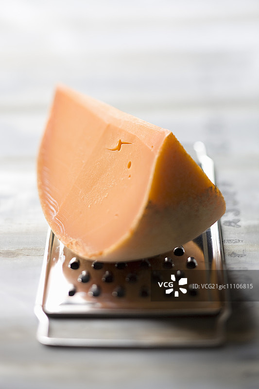 在奶酪刨丝器上的咪莫雷特奶酪角图片素材