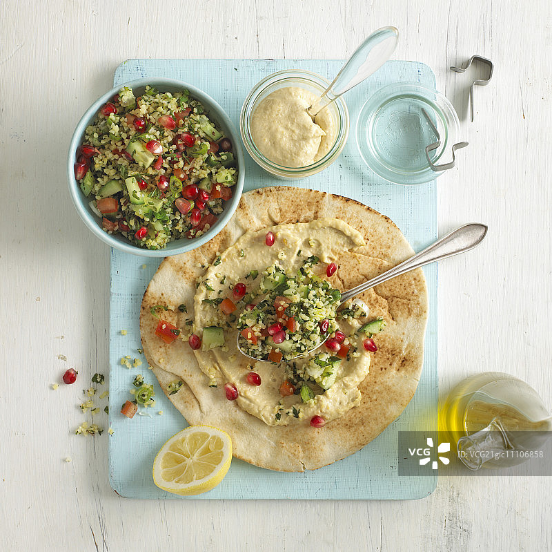 扁面包上的鹰嘴豆泥和塔布勒沙拉图片素材
