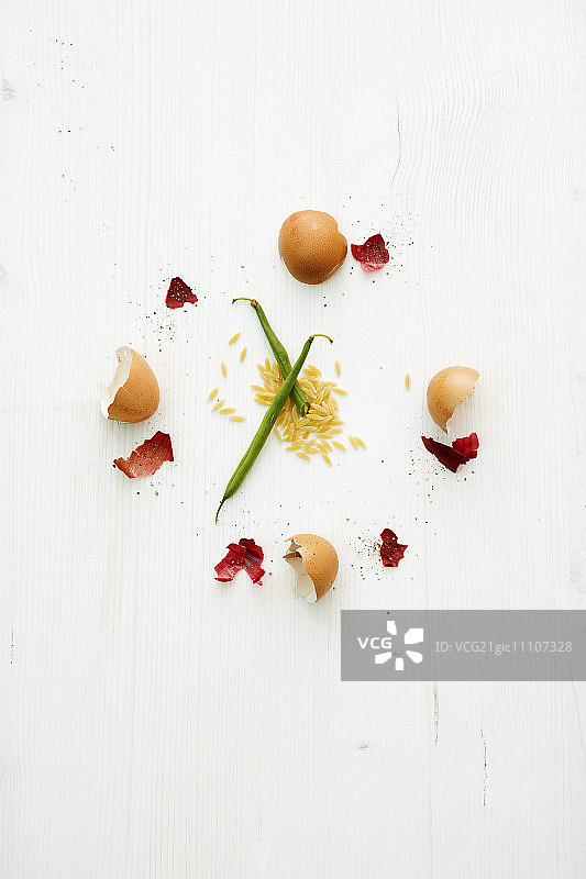 用蛋壳和洋葱皮制成的钟面，指针由绿豆制成，放在奥佐面上图片素材