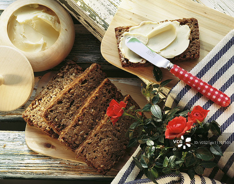 木板上的莱茵黑面包；面包和黄油；玫瑰图片素材