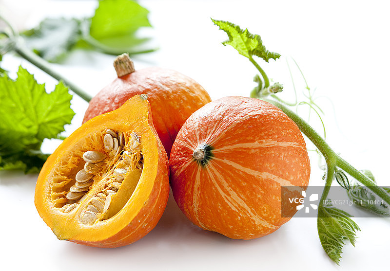 带叶的完整及切半北海道南瓜图片素材