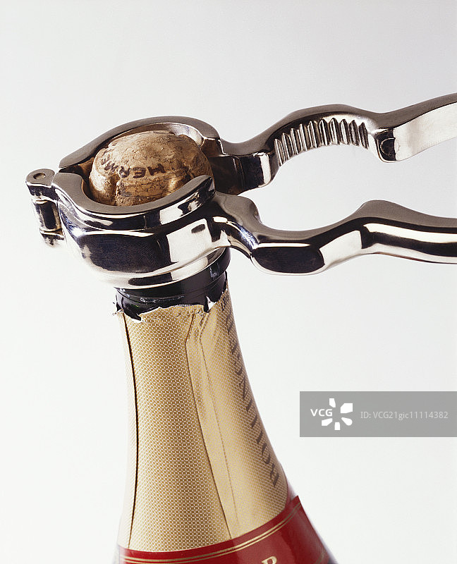 用香槟钳打开气泡酒瓶图片素材