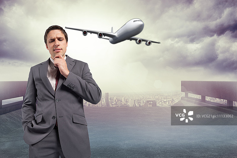 手托下巴，以城市景观为背景的沉思的商人图片素材