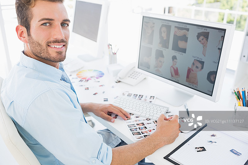 明亮办公室里使用电脑的男性照片编辑侧视图图片素材