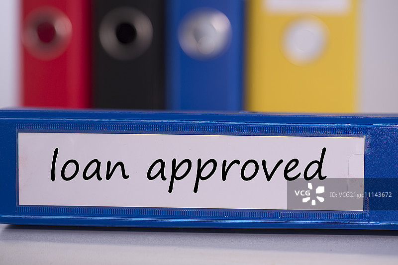 蓝色商务文件夹上的“贷款已批准”字样图片素材