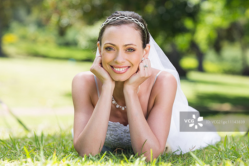 身穿婚纱的美丽新娘在公园草地上图片素材