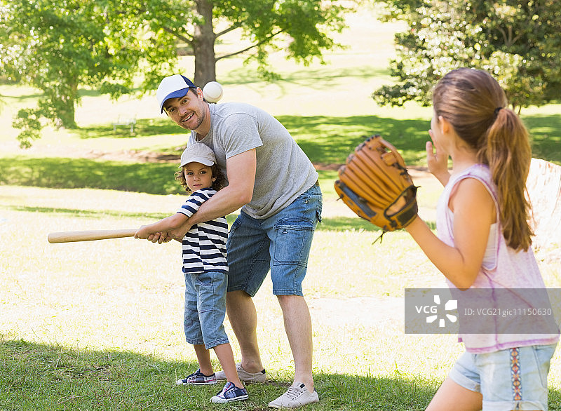 在公园里打棒球的三口之家图片素材