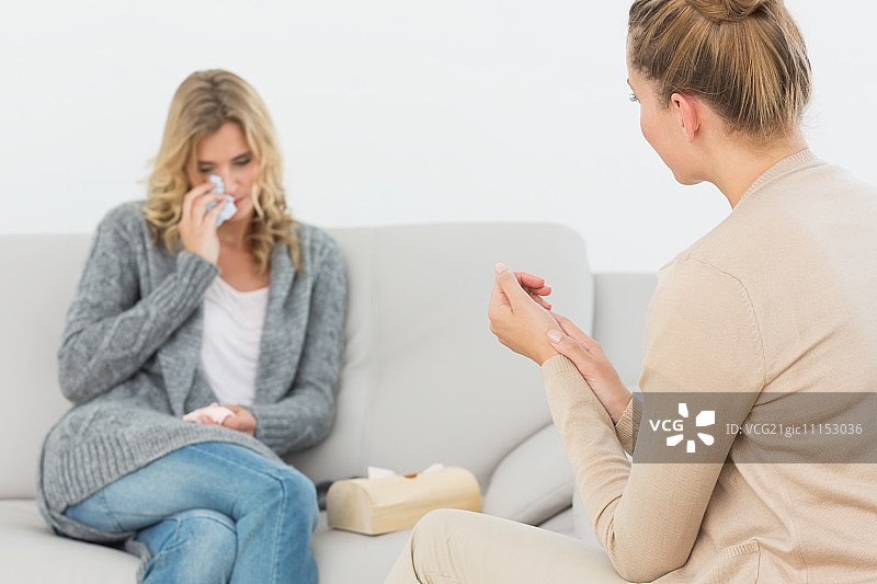 治疗期间理疗师倾听沙发上哭泣的病人图片素材