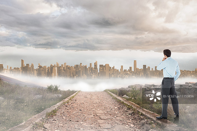 手托下巴，以通往大型城市扩张的石路为背景的沉思的商人图片素材