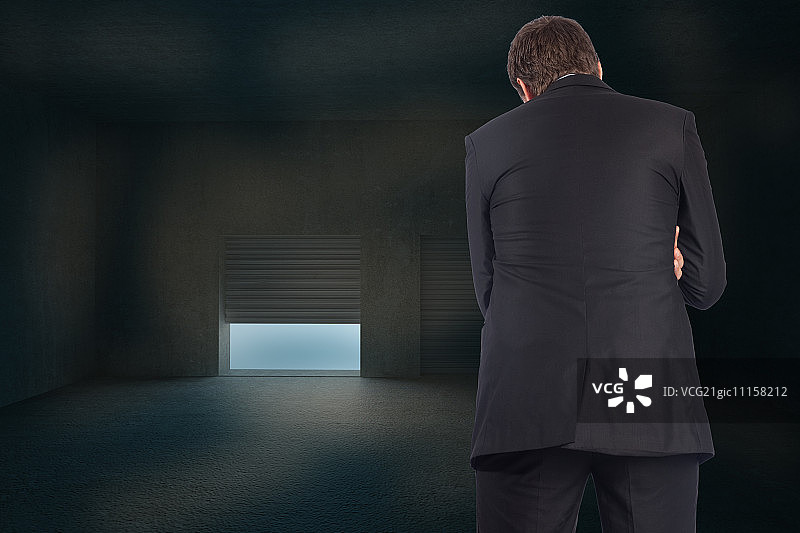 在黑暗房间的百叶窗前思考的商人图片素材