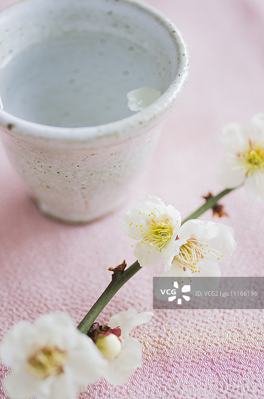 清酒杯上的梅花花瓣与梅花图片素材